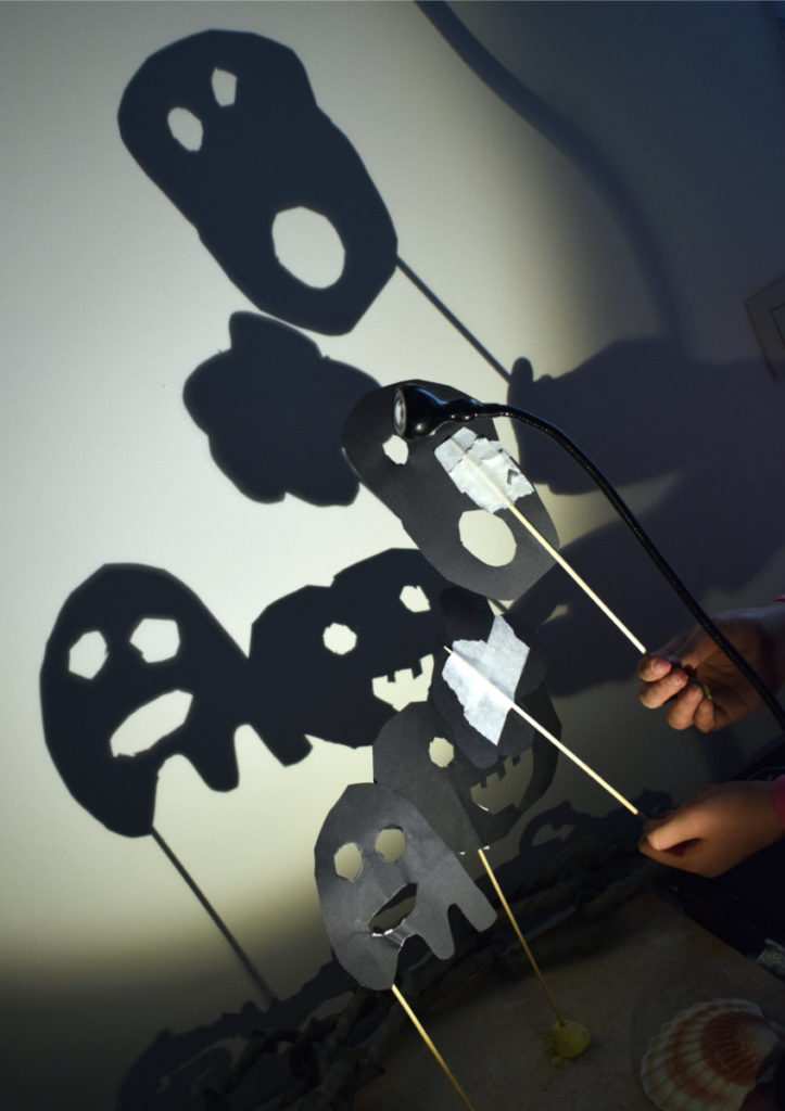 les mains d'enfants agitent les ombres des petits monstres de carton