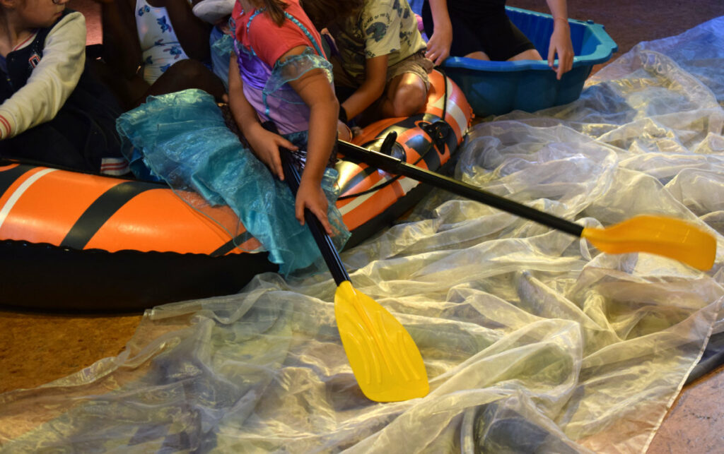 les enfants en canoë dans le théâtre de terre Franche
